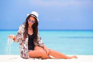 Woman sitting in white sand photo