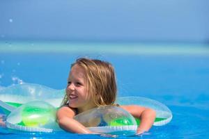 Girl in a floatie in a swimming pool photo