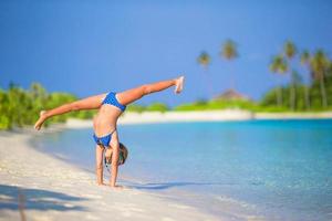 Girl doing a handstand at the beach photo