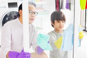 Asian father and son wiping the glass photo