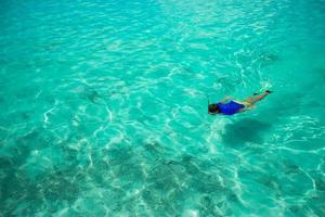 Hombre buceando en aguas tropicales claras foto