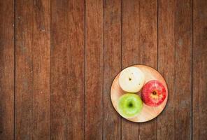 Vista superior de tres manzanas sobre un fondo de madera foto
