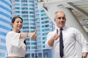 Two business people holding a thumbs up photo