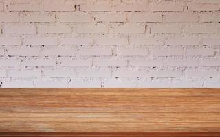 Wooden table with a white brick wall photo