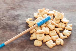 Alphabet biscuits with a pencil on a wooden table photo