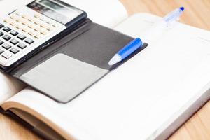 Calculator with a notebook and a pen photo