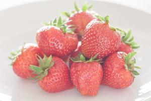 Bunch of strawberries on a white plate photo