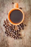 Coffee beans with a coffee cup on a wooden table photo