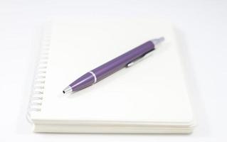 cuaderno de espiral con bolígrafo morado foto