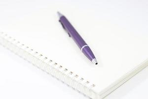 Spiral notebook and pen isolated on white background photo