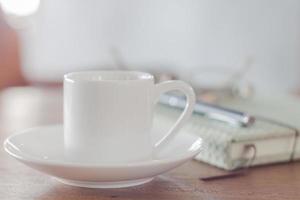 Mini white coffee cup with a notebook photo