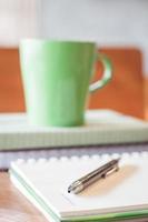 Close-up of a pen with a green coffee mug photo