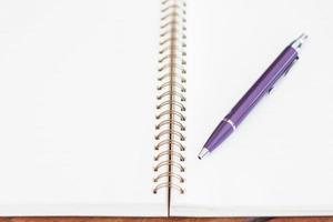 Spiral notebook with a pen on it photo