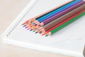 primer plano, de, lápices de colores, en, un, cuaderno espiral foto