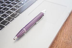 Close-up of a pen on a laptop