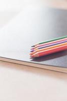 Colorful pencils on black notebook photo