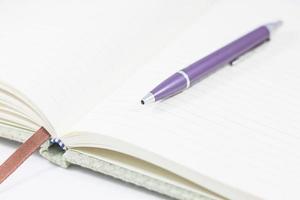 Close-up of an opened notebook with a pen photo