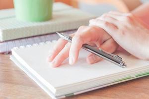 Hands holding a pen on a notebook photo