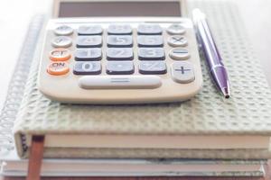 Close-up of a calculator, pen and notebooks photo