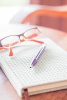 Pen and eyeglasses on a notebook on a table