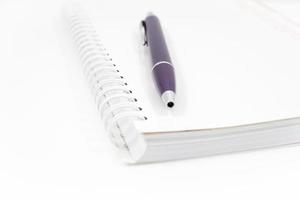 Cuaderno de espiral con un bolígrafo aislado sobre un fondo blanco. foto