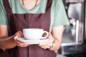 Barista holding a cup of coffee photo