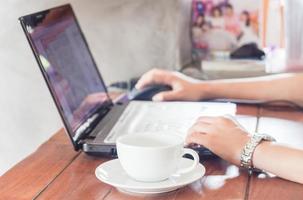 Mujer usando una computadora portátil en una cafetería. foto