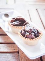 Two chocolate tarts on a wood table photo
