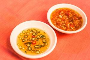 Sauce bowls on orange background photo