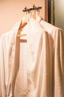 White robes on wooden hangers in a dressing room photo
