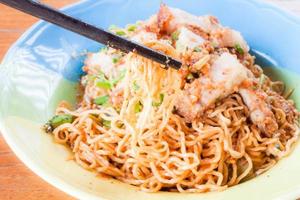 Chopsticks holding yellow noodles photo