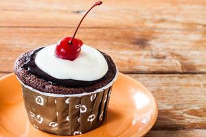 Chocolate cupcake with a red cherry photo