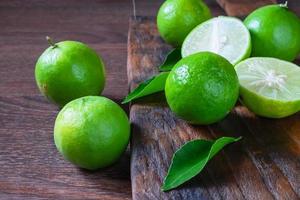 Fresh ripe limes on a wooden background photo