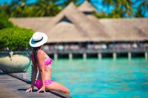 Maldivas, Asia del Sur, 2020 - Mujer sentada en un embarcadero de madera en un resort tropical