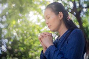 Woman praying in a garden photo