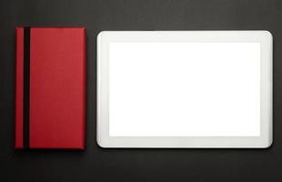 Tablet PC con pantalla en blanco y cuadro rojo sobre fondo negro foto