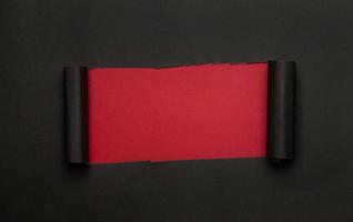 papel rasgado negro sobre fondo rojo foto
