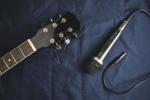 micrófono y guitarra acústica en la mesa