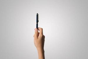 A woman's hand holds a pen isolated on white background photo