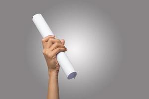 Close-up of a hand holding paper roll isolated on neutral background photo