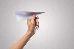 A woman's hand holds a paper airplane on white background photo