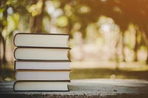 Pile of books with vintage tone on nature background photo