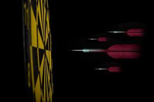 Dartboard with arrows on black background photo