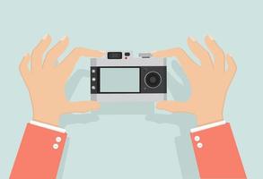 Hand holding a camera taking photos vector