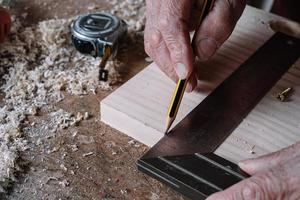 Carpenter making measurements on a table photo