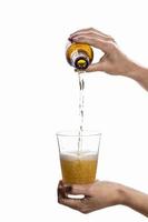 Person pouring beer into a glass on a white background