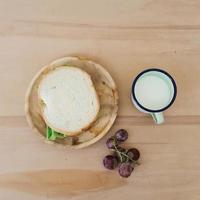 Top view of a  sandwich, milk, and grapes photo