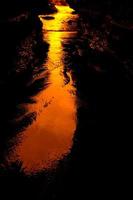 Sunset reflecting on a wet surface photo