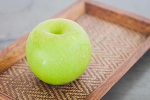 manzana verde en una bandeja de madera foto