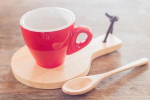 Red mug and a spoon with a wooden tray photo